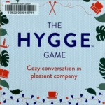 Hygge Game cover with cozy teacups, candles, plants