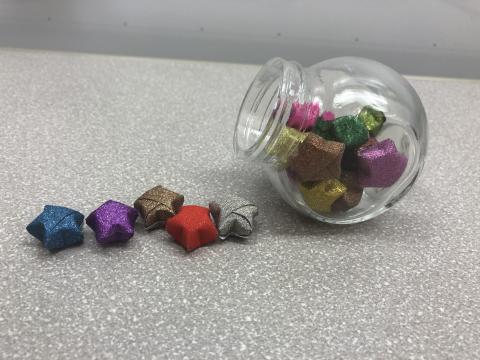 Origami stars spilling out of a small jar