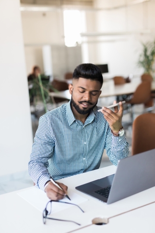 Man working using a computer and mobile device.