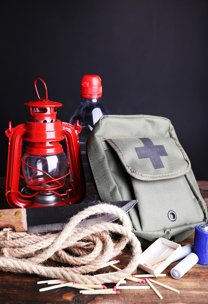 Emergency supplies including a backpack, lantern, rope, and first aid kit
