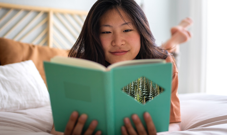 A teen girl relaxes and reads a book on her bed