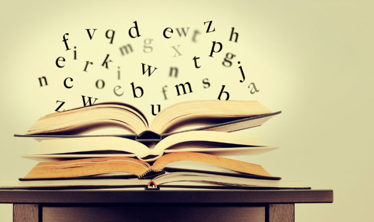 A stack of open book with floating letters above the open pages